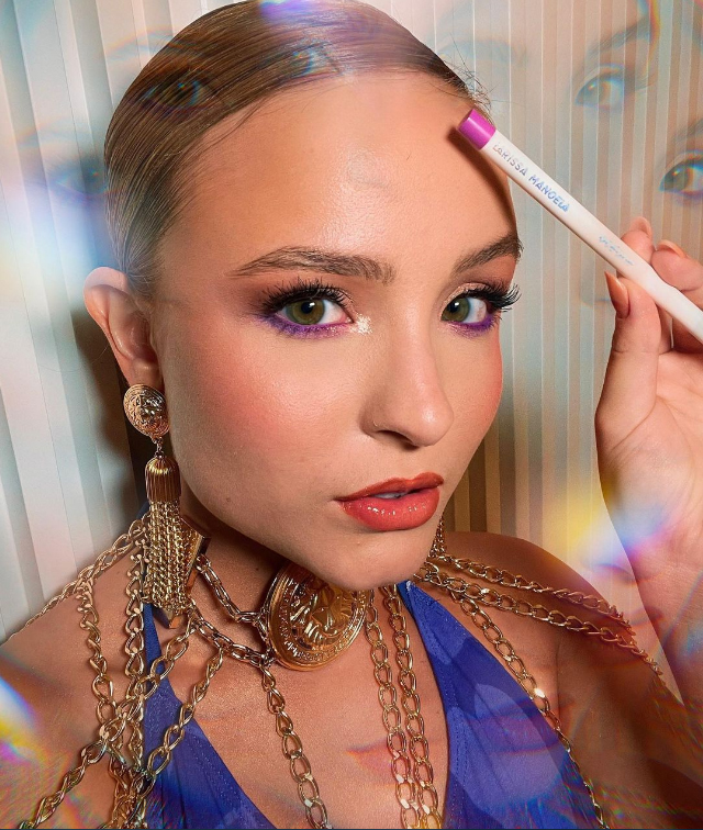 larissa-manoela-maquiagem-cilios-inferiores-coloridos Larissa Manoela usando maquiagem com lápis roxo nos cílios inferiores e expressão facial séria