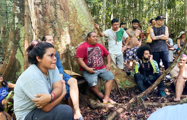 Até quando vamos continuar desumanizando o debate climático e ambiental? Fotos de um grupo de pessoas conversando no pé de uma árvore, no meio da Floresta Amazônica
