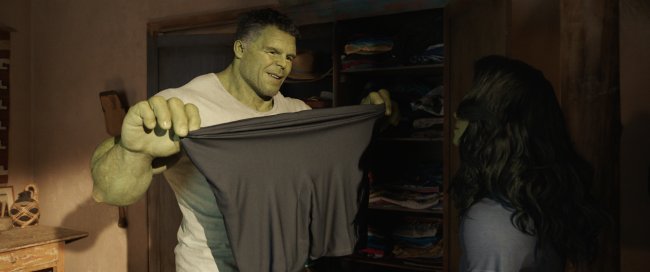 mulher-hulk Hulk e Mulher-Hulk conversando. Ele segura uma camiseta preta esticada.