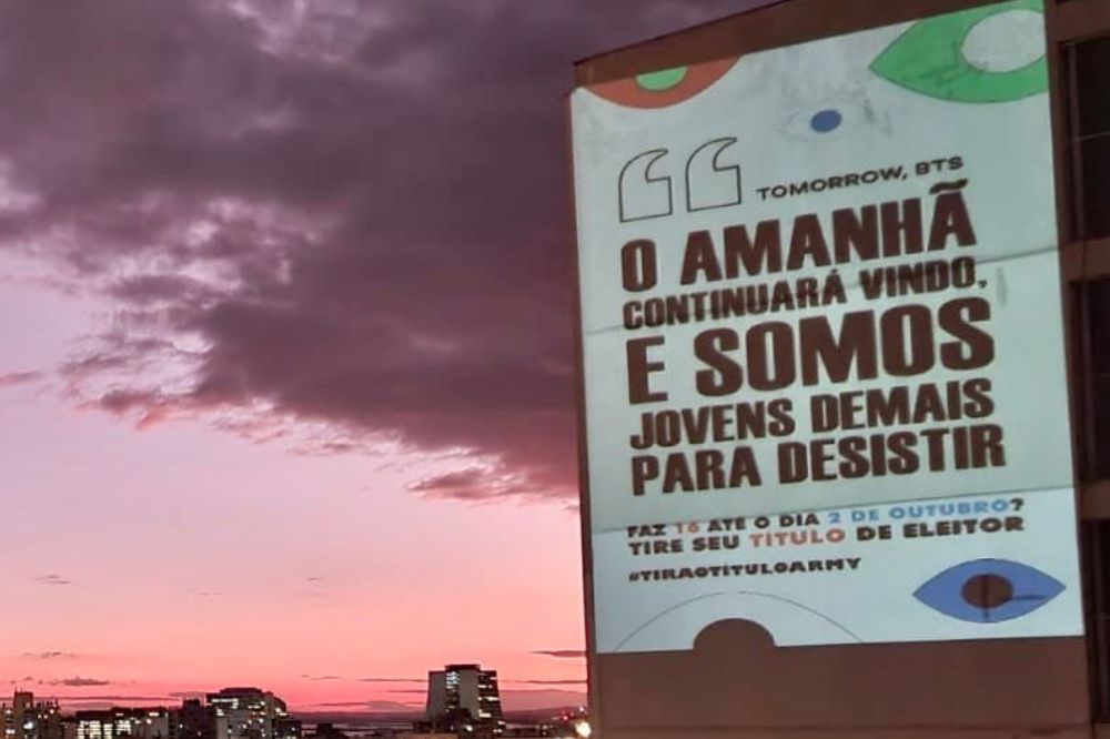 Projeção de frases em prédio ao por do sol