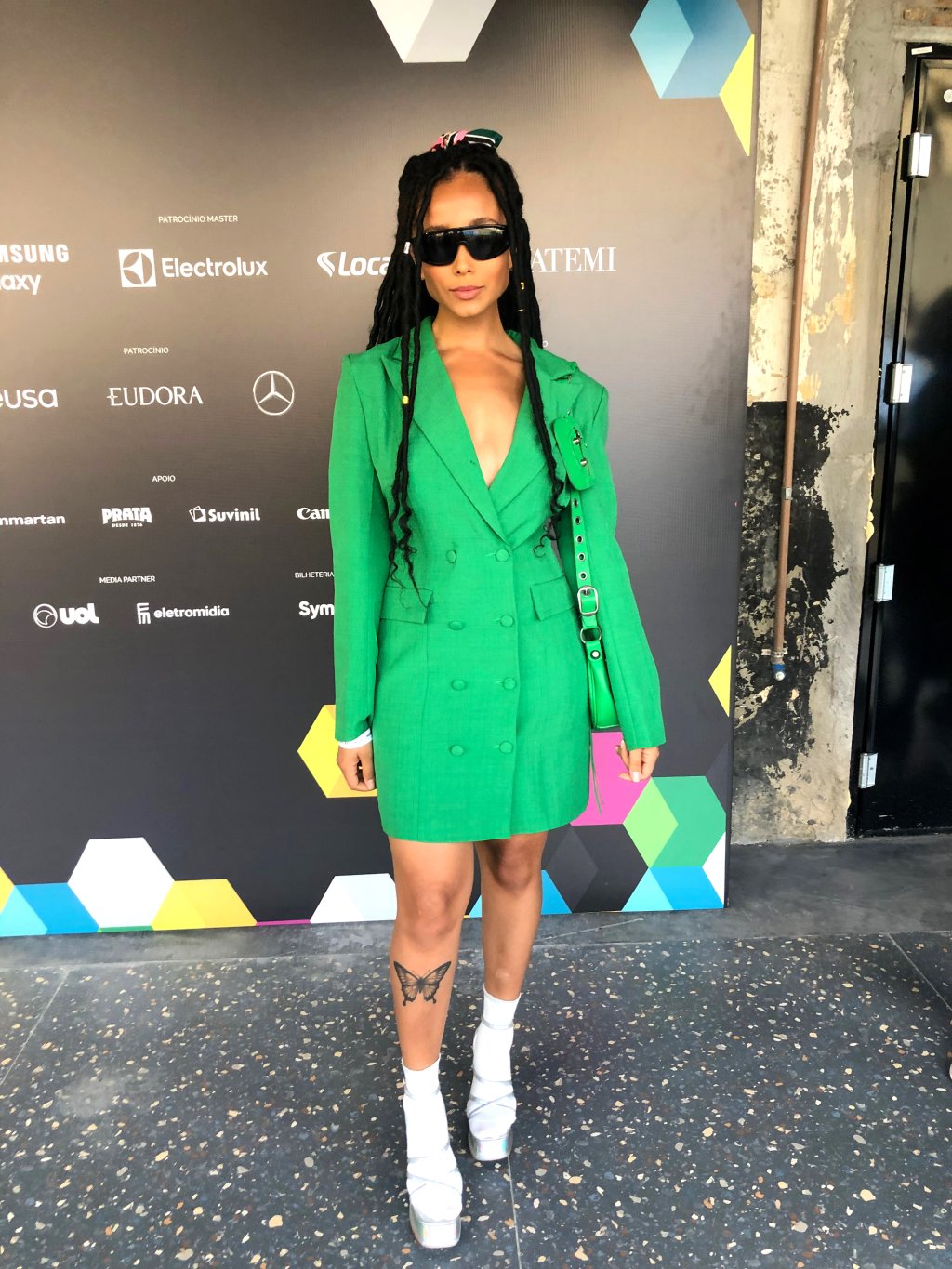 Look do São Paulo Fashion Week N54 com blazer-vestido verde, sandália prata e meia, óculos de sol futurista