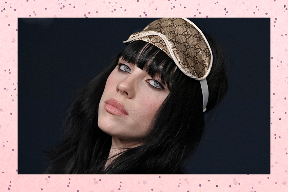 Montagem com foto de Billie Eilish com expressão facial séria em fundo rosa com bolinhas