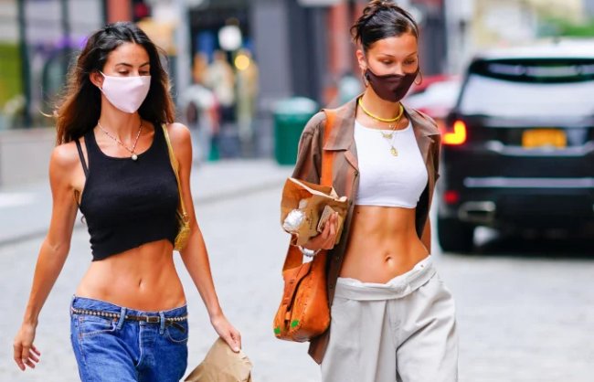 Bella Hadid e amiga usando calça de cintura baixa em looks casuais Bella Hadid e amiga usando calça de cintura baixa em looks casuais
