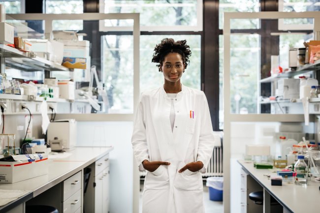 Portrait of a black female scientist Pessoa cientista entre bancadas de laboratório