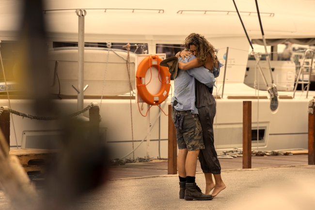 Imagem de JJ e Kiara, personagens de Outer Banks, se abraçando