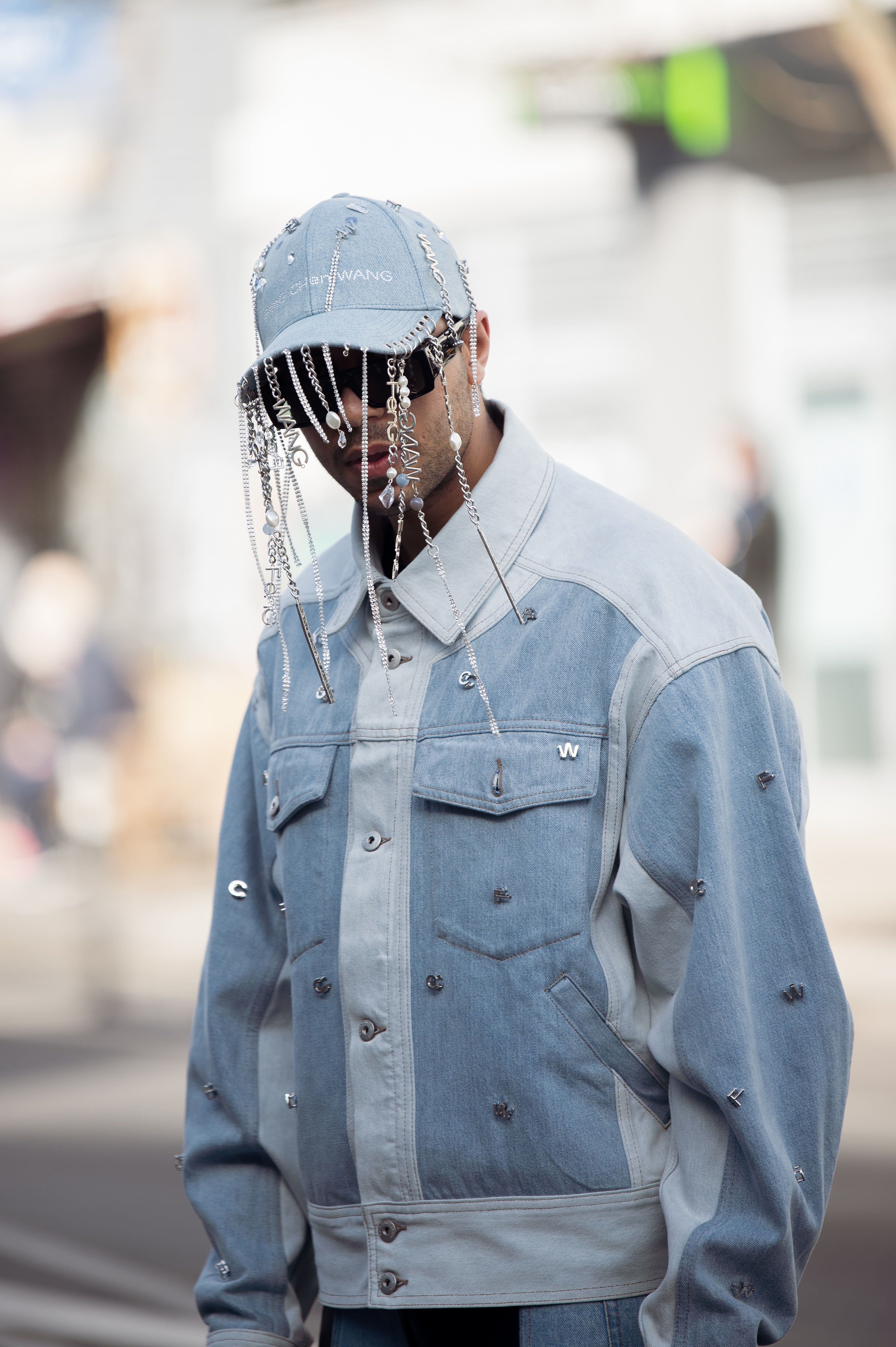 Street Style – LFW February 2023 Homem usando look jeans com boné jeans que possui aplicações de strass no street style da semana de moda de Londres
