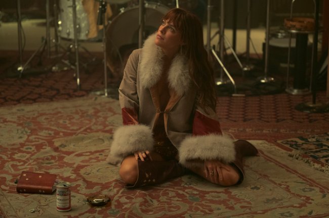 look-com-casaco-daisy-jones-and-the-six Foto de uma cena da personagem Daisy Jones da série Daisy Jones and The Six.