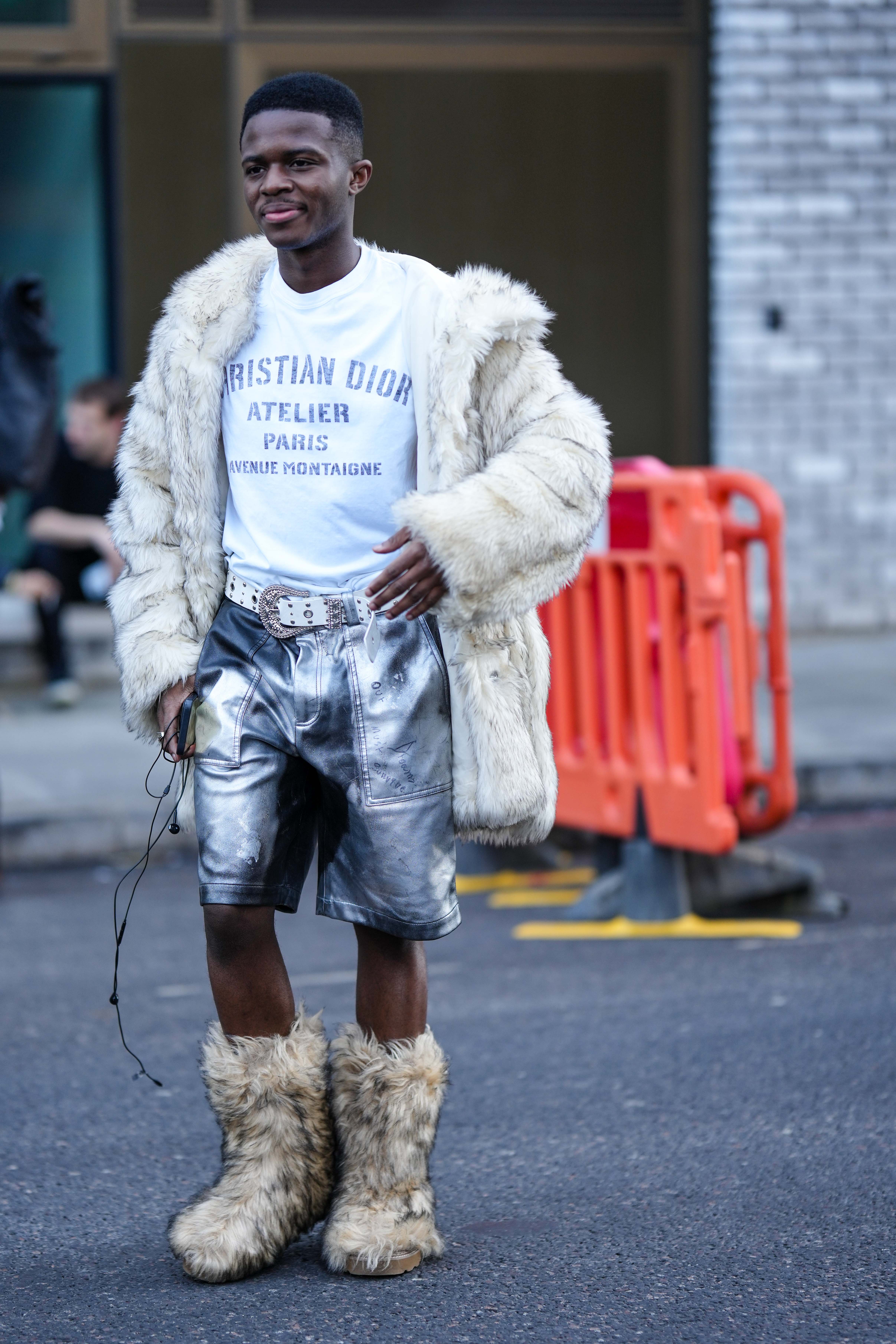 Street Style – LFW February 2023 Look com camiseta branca, casaco fofo, bota e bermuda metalizada em prata no street style da semana de moda de Londres