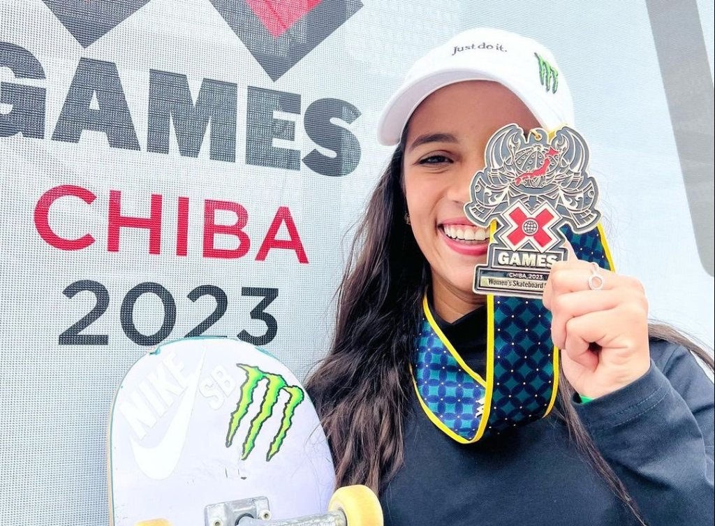 Rayssa posiciona a medalha de ouro na frente de um dos olhos para exibir a vitória no X-games