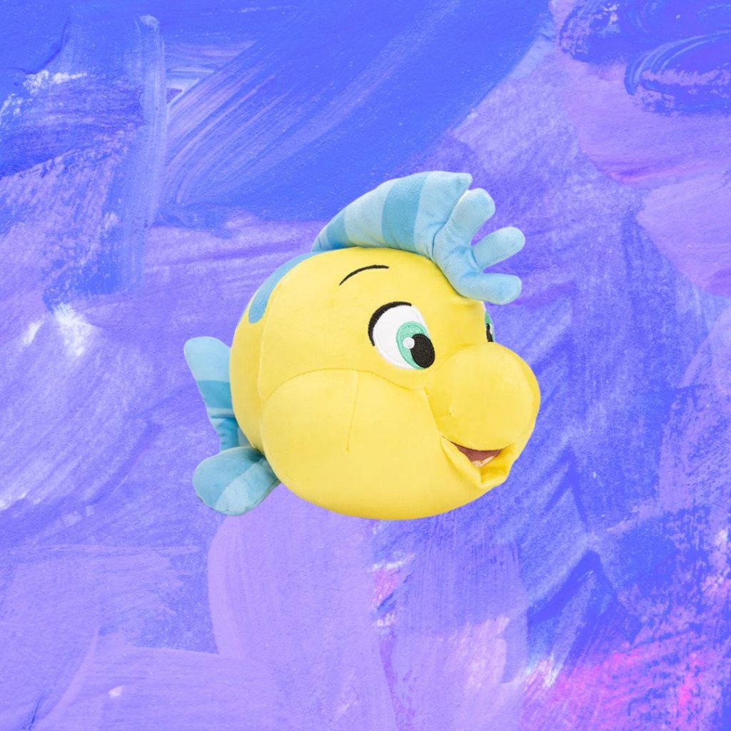 linguado Pelúcia do peixe Linguado de A Pequena Sereia; o fundo é uma textura de tintas em tons de azul e roxo