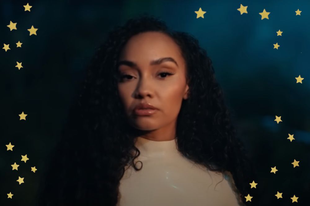 Leigh-Anne em cena do clipe de Don't Say Love; ela está com expressão séria olhando para frente; ela usa uma roupa branca com gola alta e está com expressão neutra; estrelas amarelas decoram a imagem