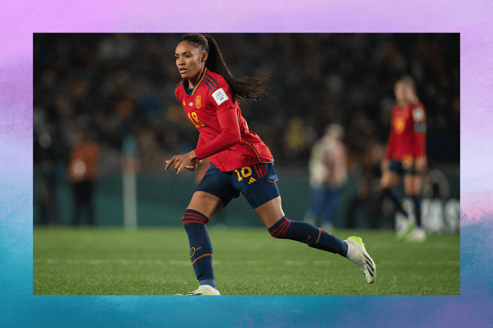 Mulher joga bola, ela usa uniforme vermelho e azul