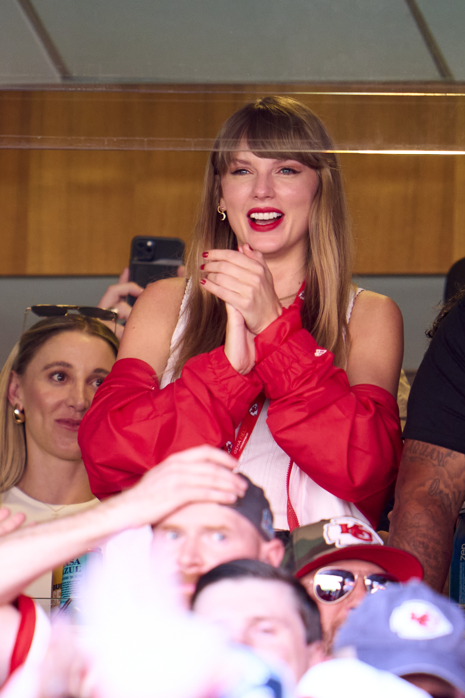 Taylor Swift assiste jogo do Kansas City Chiefs contra o Chicago Bears; ela está sorrindo enquanto bate palmas