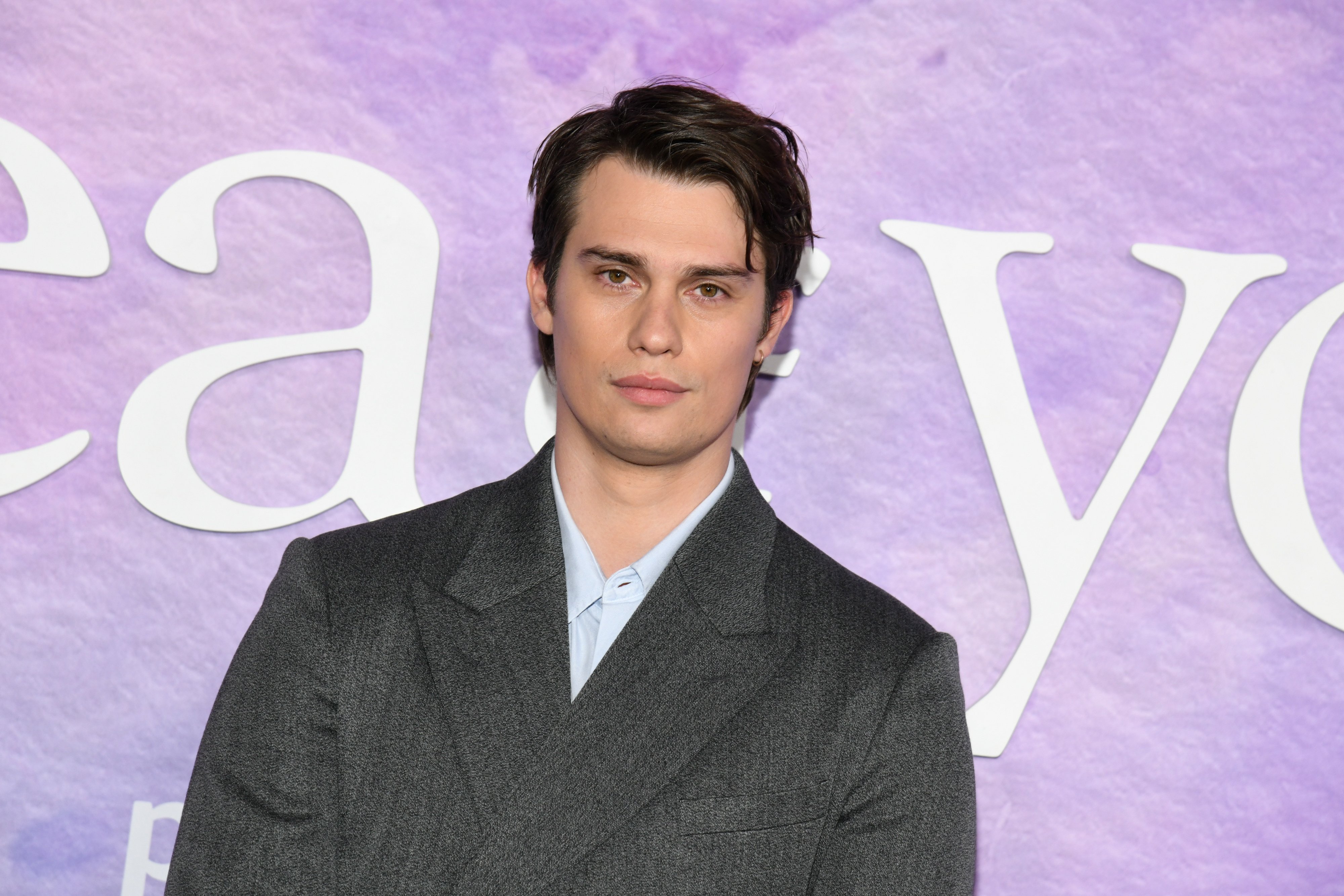 Nicholas Galitzine posando para foto com expressão neutra na première de A Ideia de Você