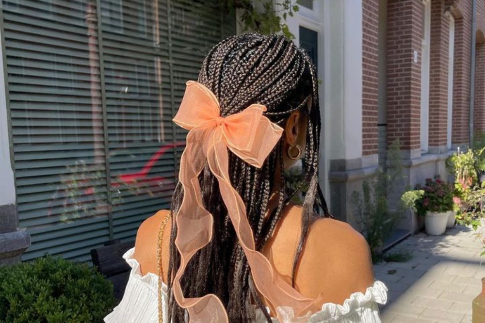 Cabelo com tranças box braids e um laço