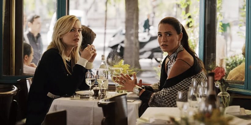 Cena de Emily em Paris, com Camille e sua amante em um restaurante.