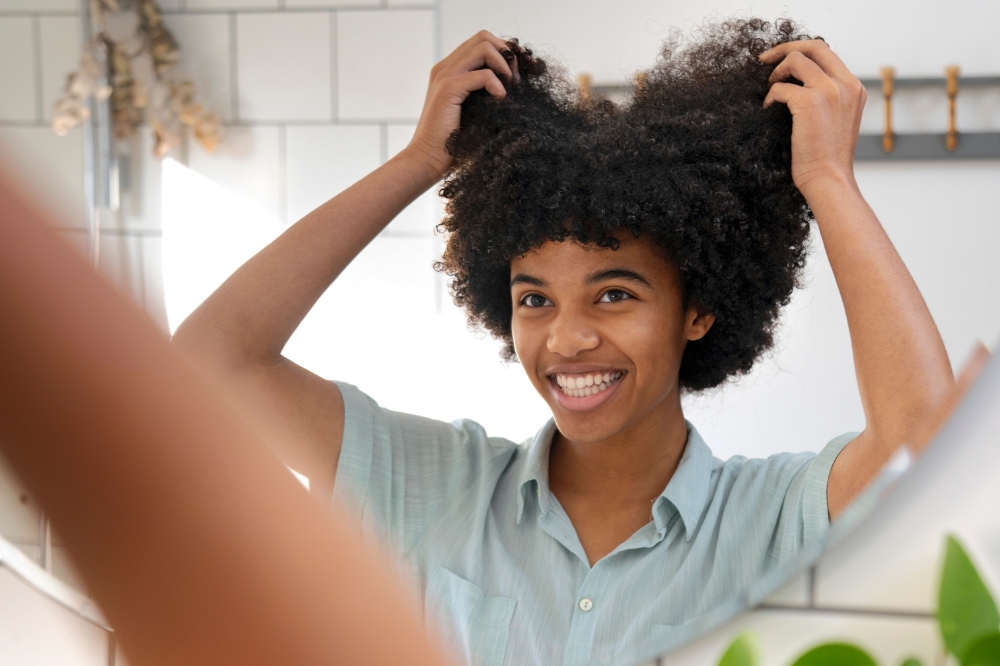 Jovem de cabelo crespo na frente do espelho