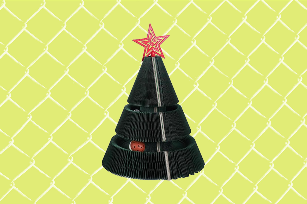 Imagem de um gato ao lado de uma árvore de Natal de arranhador.