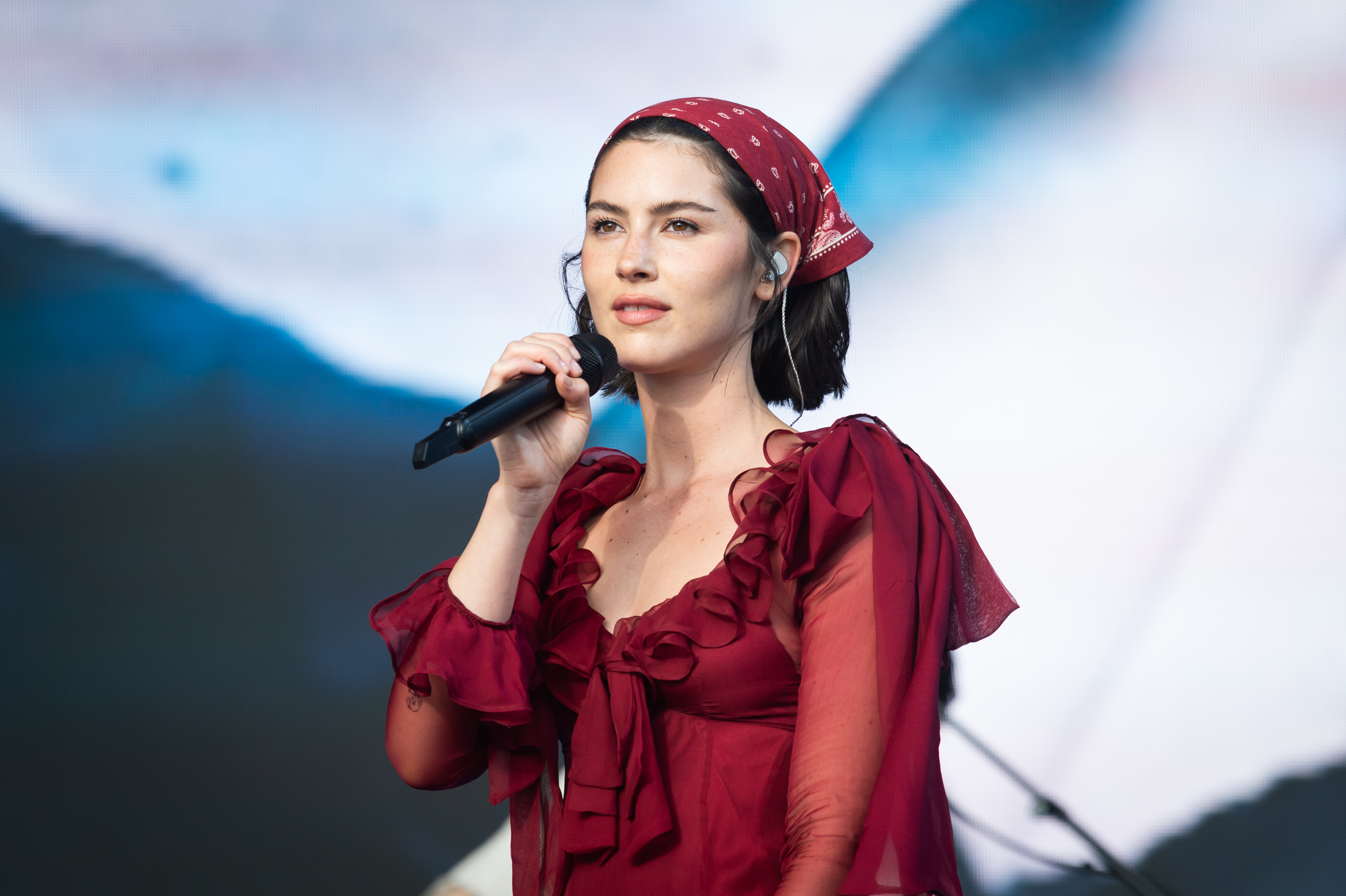 Gracie Abrams em show no Glastonbury 2025 usando bandana e vestido vermelhos