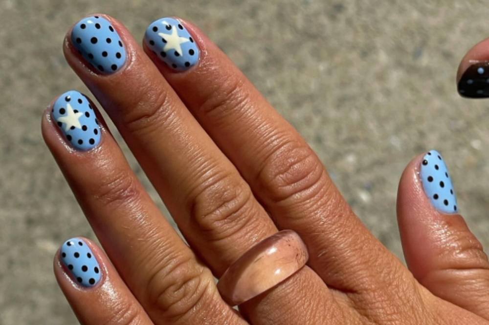Unhas com esmalte azul claro e decoradas com bolinhas