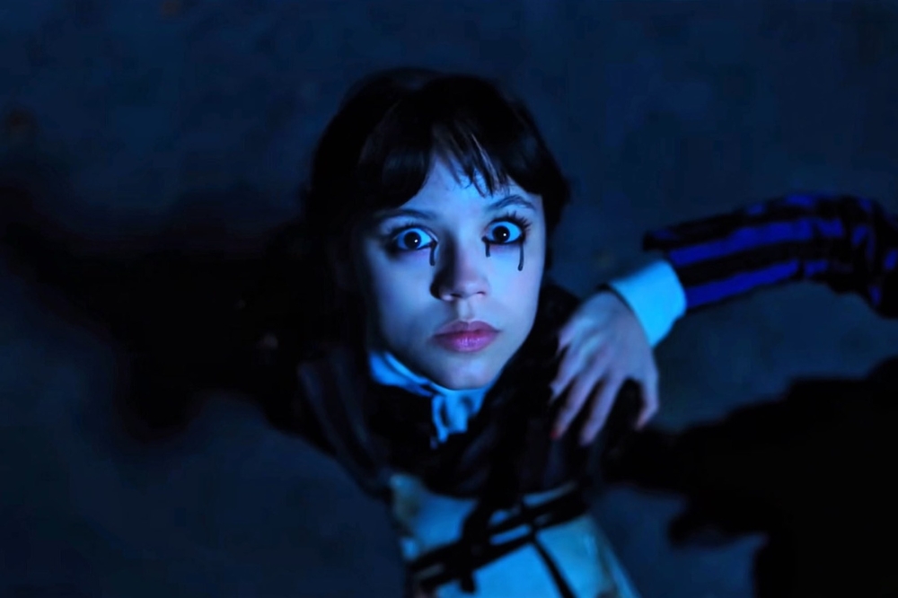 Jenna Ortega como Wandinha na segunda temporada da série da Netflix com lágrimas pretas nos olhos e olhando para cima