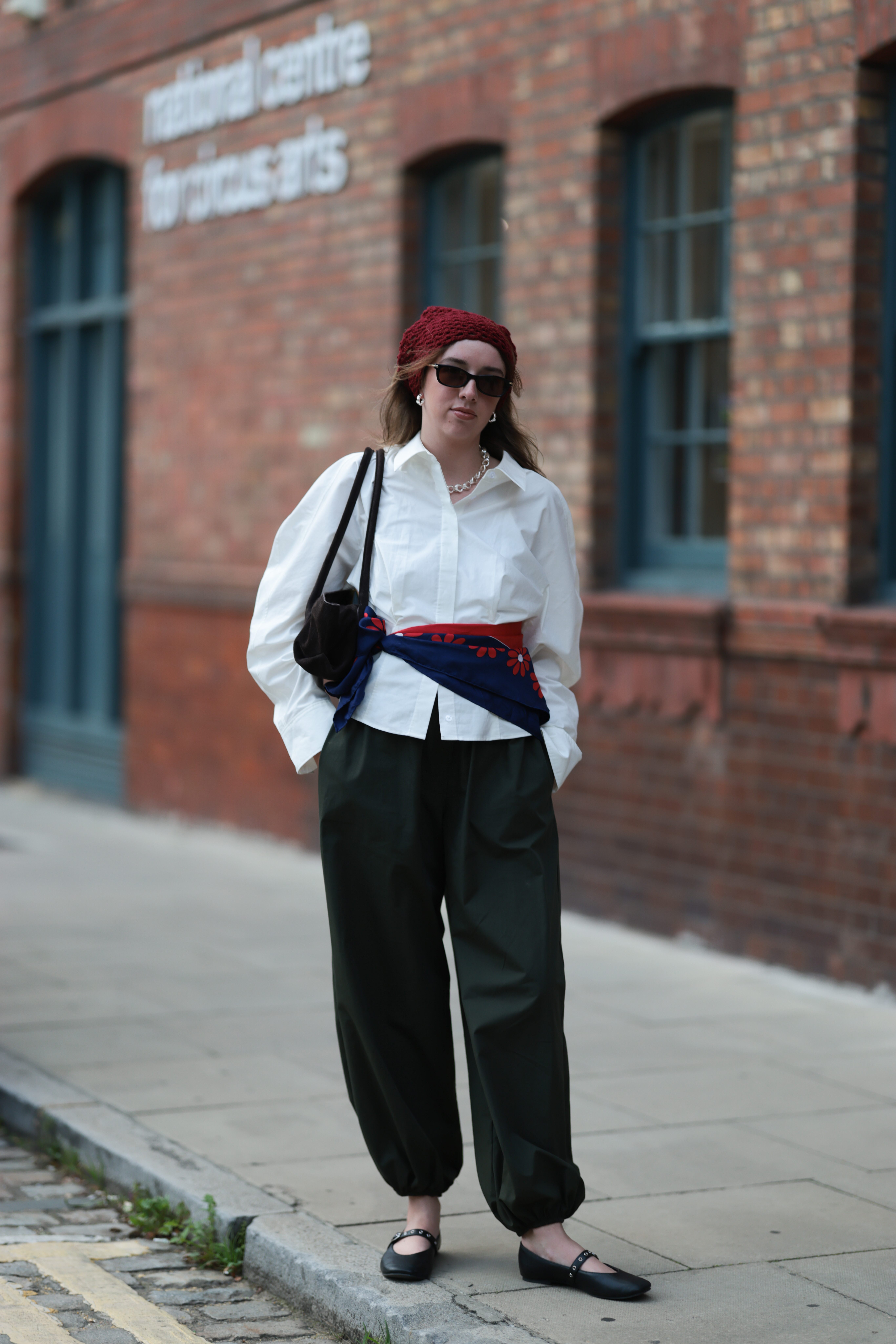 Uma convidada veste uma camisa branca de botões apertada na cintura com um lenço azul marinho antes do EBAY ENDLESS RUNWAY Show durante a London Fashion Week