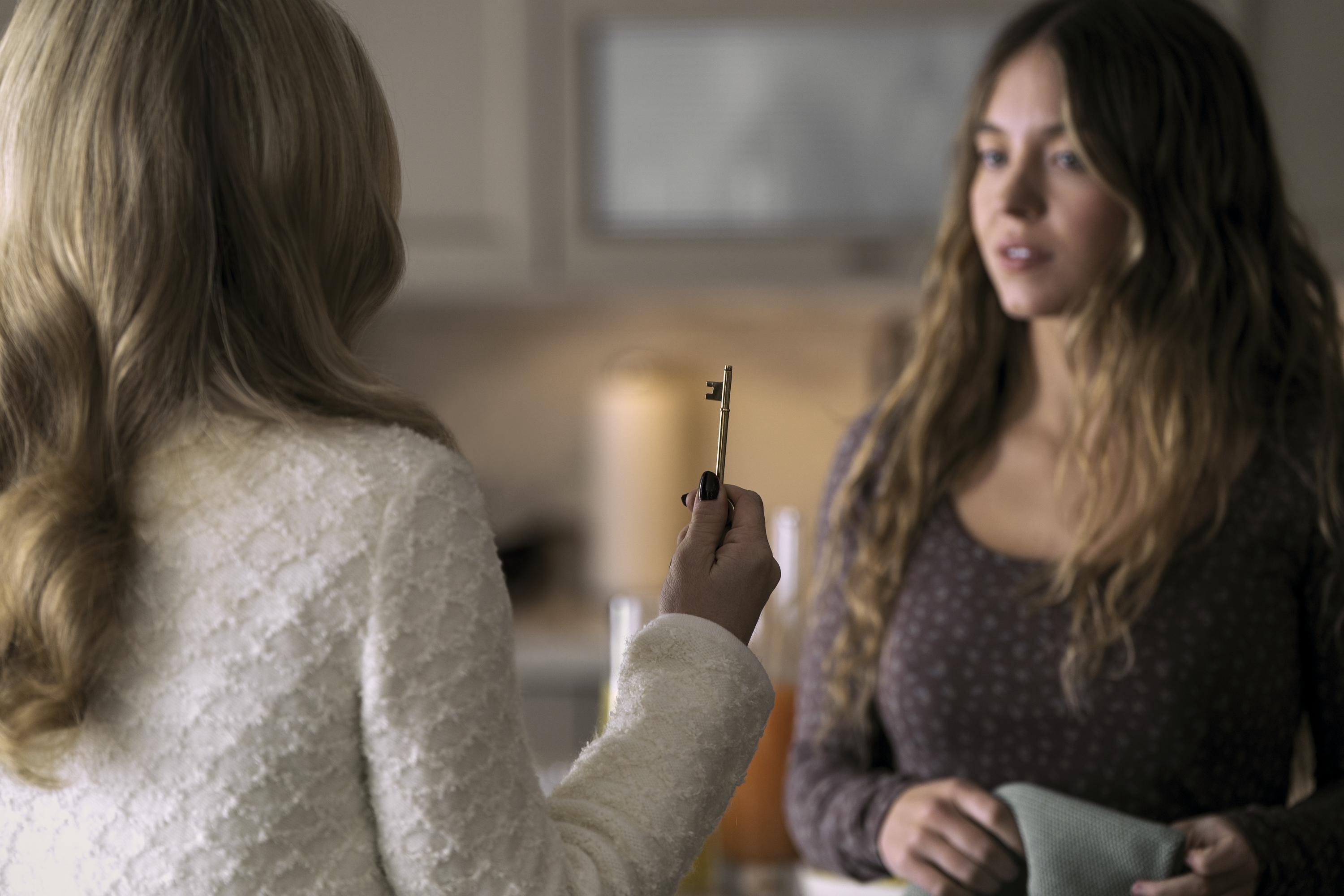 Sydney Sweneey de cabelos longos Amanda Seyfried segurando chave