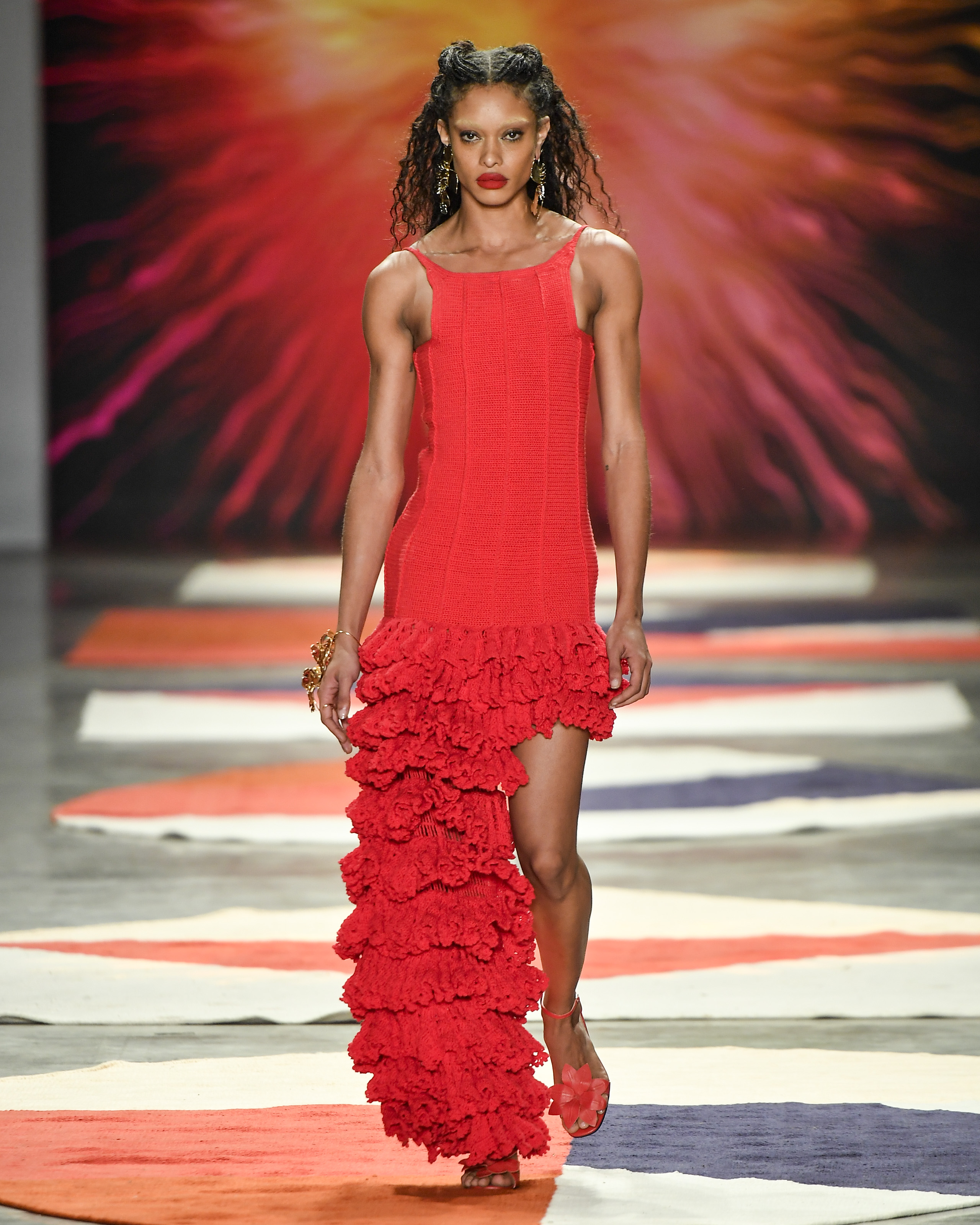 Modelo desfilando para a marca Ateliê Mão de Mãe com sobrancelha descolorida e batom vermelho