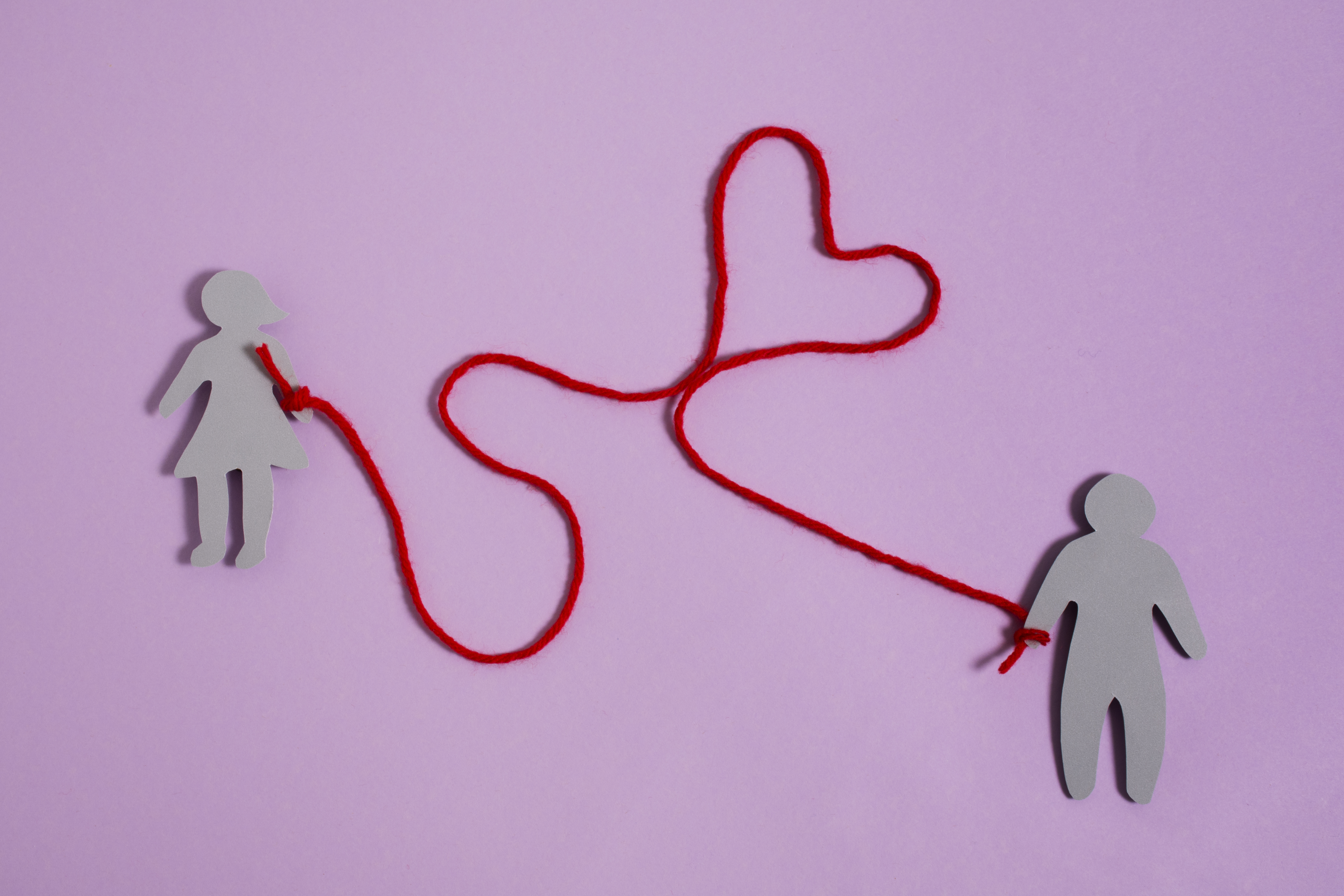 Laço vermelho entre duas figuras
