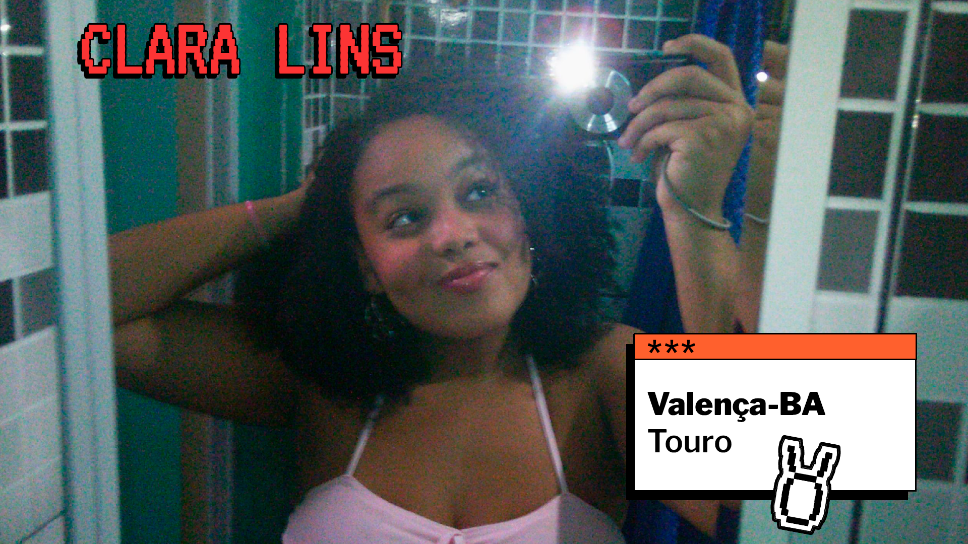 Selfie de uma jovem com cabelos cacheados, sorrindo diante do espelho enquanto segura o celular com flash. No topo da imagem está escrito “Clara Lins”. À direita, há um quadro com as informações “Valença-BA” e “Touro”, acompanhado de um ícone do signo.