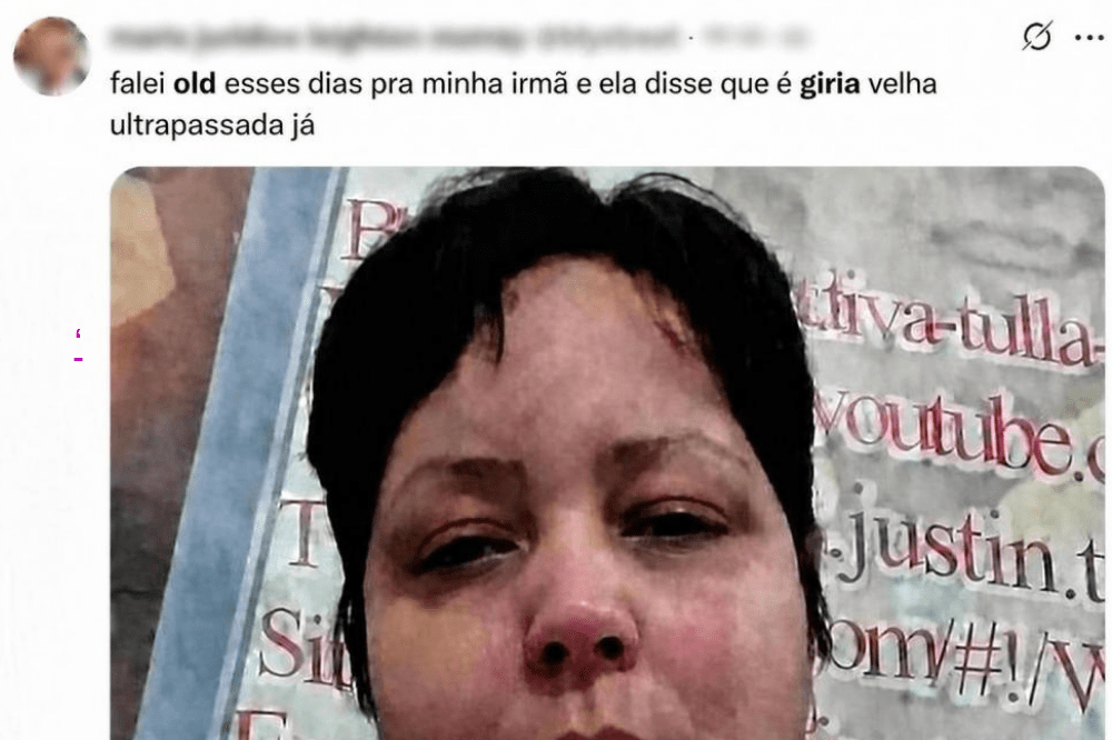 Rosto de uma mulher com cabelo escuro curto, olhos fechados e pele avermelhada, em um fundo com texto ilegível