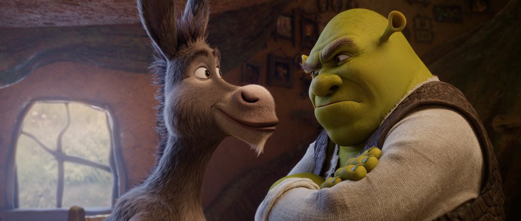 O Burro sorri para Shrek, que está de braços cruzados e com expressão de irritação, em um ambiente interno com janela ao fundo