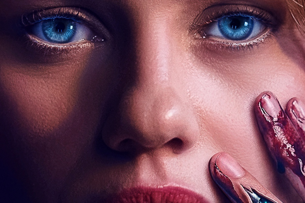 Rosto de mulher com olhos azuis intensos e lábios vermelhos, uma mão com unhas sujas de sangue toca sua bochecha, transmitindo tensão e mistério
