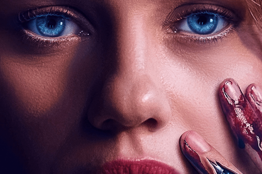 Rosto de mulher com olhos azuis intensos e lábios vermelhos, uma mão com unhas sujas de sangue toca sua bochecha, transmitindo tensão e mistério