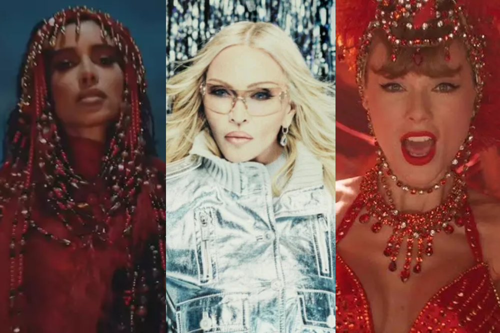 Três mulheres em close-up: à esquerda, uma mulher de pele morena com adereço de cabeça vermelho e dourado; ao centro, Madonna loira com óculos e jaqueta prateada; à direita, Taylor Swift com maquiagem forte, chapéu e colar vermelhos, boca aberta em expressão de canto