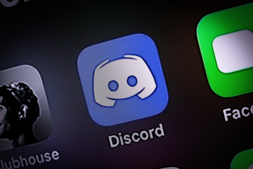 Ícone do aplicativo Discord em azul e branco, com o nome Discord abaixo, em uma tela de smartphone com outros ícones desfocados