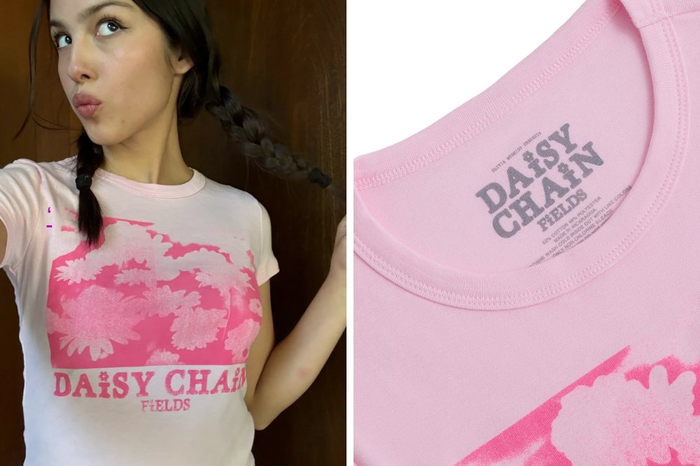 Olivia Rodrigo com tranças, vestindo camiseta rosa claro com estampa de margaridas e o texto DAISY CHAIN FIELDS em rosa choque. À direita, detalhe da etiqueta interna da gola da camiseta com o mesmo texto e informações de composição e lavagem